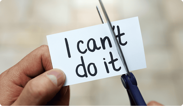 A hand cutting “I can’t do it” into “I can do it” – symbolising self-belief and motivation.